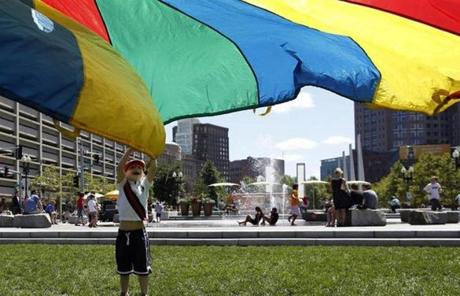 Sam Lottner of New York City played with a rainbow-design parachute on the Greenway.

